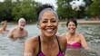 © Iona - A vibrant senior woman beams with joy as she stands waist-deep in water, surrounded by others, embodying vitality and community on a sunny day.