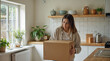 © Sachin - Woman unpacking cardboard box.  New home, moving day, relocation.  House, apartment, organizing.