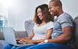 © peopleimages.com - Happy, home and black couple on laptop on sofa for online shopping, search website and internet store. Dating, relax and man and woman on computer for bonding, relationship and chill on weekend