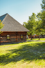 Wall Mural - Rare wooden bell tower with folk houses located in open-air museum of Liptov Village, Slovakia - Pribylina