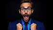 © Anna - man in a blue suit shows excitement with an open mouth and wide eyes, raising his fists in jubilation against a solid dark backdrop, conveying strong emotions