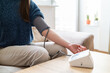 © Stefan - Young woman measuring blood pressure at home close up