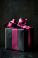 Wall Mural - Elegant black gift box with luxurious pink ribbon on dark background