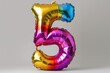 © Marat - Multi-colored foil balloons in the shape of number 5 on a white background