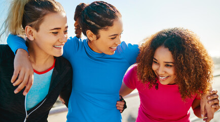 Poster - Women, group and hug for exercise by ocean, smile and love on promenade in summer sunshine. Girl, people and friends with diversity, connection and embrace for fitness, workout and training by sea