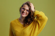 © Alliance - Portrait of happy healthy woman in sweater and glasses on green