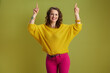 © Alliance - happy healthy woman pointing isolated on green