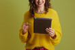 © Alliance - happy fit woman using digital tablet on green background