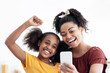 © Prostock-studio - Emotional african american mother and daughter sitting at kitchen table taking selfie together while spending time together, happy black mom and kid having video chat, using cellphone, copy space