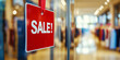 © RookStock - Bright red 'SALE!' sign on a glass store window, reflecting the interior of a clothing shop, retail and shopping discount concept