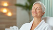 © Keopaserth - serene middle aged woman in white bathrobe enjoys moment of relaxation, embodying tranquility and self care in soothing environment