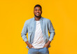 © Prostock-studio - Portrait of confident african american man standing with hands in pockets on yellow background with free space