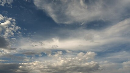 Wall Mural - Time lapse of white summer clouds drift across a dark blue sky. Only sky shown
