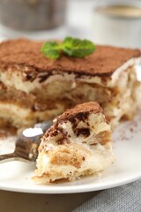 Canvas Print - Piece of tasty tiramisu on table, closeup