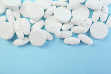 Wall Mural - Many antibiotic pills on light blue background, top view. Space for text