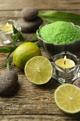 Wall Mural - Spa composition with fresh limes, sea salt and burning candles on wooden table, closeup