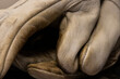 © Chris - Close-up of a pair of well-worn, dirty industrial goatskin work gloves, showing signs of heavy use and wear, perfect for showcasing the rugged durability needed for tough, hands-on labor