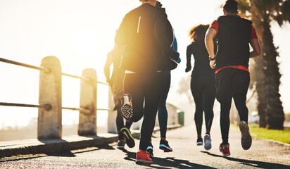 Poster - People, back and running with group for fitness, cardio workout or exercise together on promenade. Friends, active community or team of runners in race, sprint or marathon on sidewalk by ocean coast