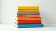 © Mali - A vibrant stack of colorful books, neatly arranged on a pristine white surface, symbolizes knowledge, learning, and the joy of reading