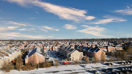 Snow-dusted houses in a residential neighborhood on a sunny winter day.