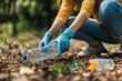 © TuruMuru - Unidentified female gardener collecting plastic bottles for recycling while wearing gloves