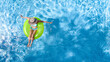 © Iuliia Sokolovska - Active young girl in hat in swimming pool aerial drone view from above, teen relaxes and swims on inflatable ring donut and has fun in water on family vacation, tropical holiday resort