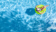 © Iuliia Sokolovska - Active young girl in hat in swimming pool aerial drone view from above, teen relaxes and swims on inflatable ring donut and has fun in water on family vacation, tropical holiday resort