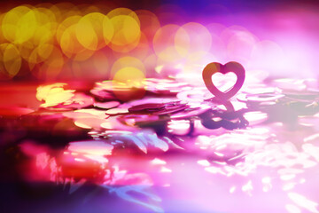 Wall Mural - Abstract colored background. Red toy in the shape of a heart on a glitter and bokeh background.