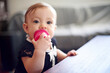 © peopleimages.com - Biting, teething and toy with baby at table in home for child development, coordination or growth. Chewing, curiosity and motor skills with infant girl in living room of apartment for discovery