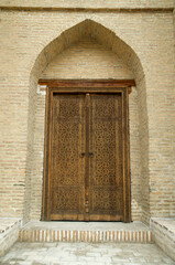 Wall Mural - Ancient Uzbek architecture with carved wooden door in Bukhara, Uzbekistan