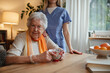 © Halfpoint - Caring healthcare worker visiting a senior patient at home.