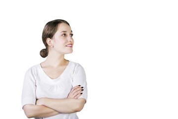 Poster - Young woman in white shirt with arms crossed, smiling and looking sideways, isolated on white background. Concept of confidence and positivity