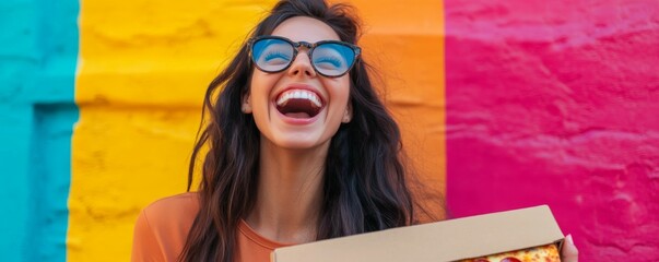 Wall Mural - Happy young woman with a pizza box in a colorful setting, expressing joy.