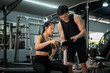 © bongkarn - A beautiful and fit Asian female client discussing her workout program with her fitness trainer.