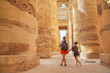 © Igor - Egypt - karnak hypostyle hall columns in the temple at luxor thebes and happy tourist girls - mother and daughter on vacation.