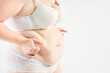 © staras - Tummy tuck, flabby skin with stretch marks on a fat belly, plastic surgery concept on light gray background