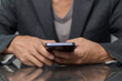 © AK ST - Close-Up of Person Holding Smartphone in Black Suit Coat