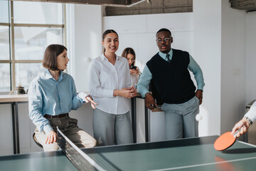 Wall Mural - A group of multicultural business workers take a break from work to enjoy playing table tennis in a modern office setting, fostering teamwork and relaxation.