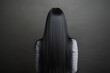 © NataliPro - A woman with long black hair, viewed from the back, wearing a striped shirt against a dark background.