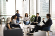 © fizkes - Six young professionals staff members talking gather together in office hall preparing for formal meeting or negotiations, share strategy, goals and solutions. Decision-making, briefing, communication