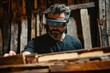 © Anjali - A bearded man uses AR glasses to examine wooden planks in a workshop, likely for a woodworking project.
