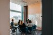 © Maskot - Male entrepreneur taking team meeting with colleagues in board room at office