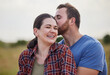 © Nina Lawrenson/peopleimages.com - Outdoor, couple and love with kiss on farm, sustainable environment and agro field with support. Countryside, man and woman with affection embrace for admiration, agriculture and farmer in Australia