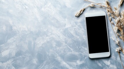 A rustic smartphone is showcased against a textured blue background adorned with dried grass, invoking a natural and earthy theme suitable for organic concepts.