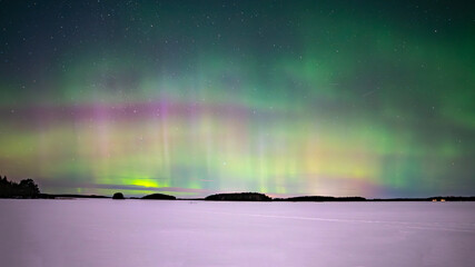 monnlight lake with northern lights danzing over frosen lake in farnebofjarden national park in nort