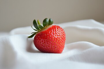 Wall Mural - A single ripe strawberry rests on white fabric