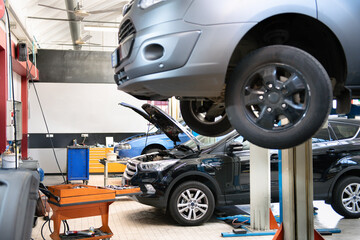 Wall Mural - Cars undergoing maintenance and repair in busy auto repair shop