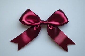 Wall Mural - A single red satin bow sits on a white surface, perfect for decorations or packaging