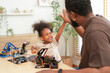 © Jestercine - Excited father and daughter giving a high five after successfully assembling a robotics project, enjoying a fun and educational STEM activity that fosters teamwork and creativity at home