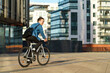 © muse studio - Bicyclist riding in a modern cityscape during late afternoon sunlight near residential buildings